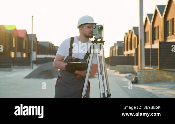 Professional land surveyor working with a theodolite on a tripod ...