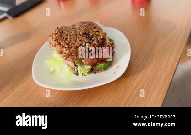 A homemade Japanese-style rice burger featuring grilled pork and fresh ...
