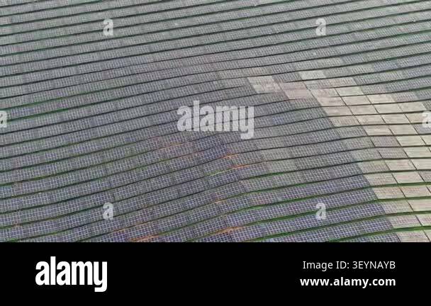 Aerial drone footage showing rows of photovoltaic panels arranged in a ...