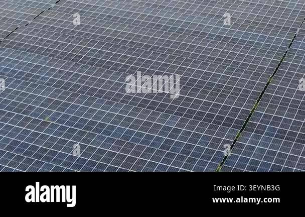 Aerial drone footage showing rows of photovoltaic panels in a ground ...