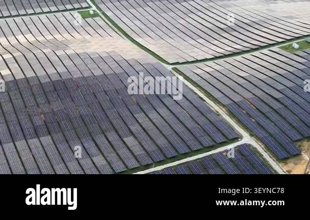 Aerial drone footage of a ground mounted solar panel farm with service ...