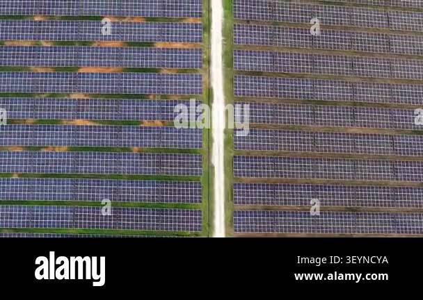 Top-down drone footage showing organized rows of solar panels separated ...