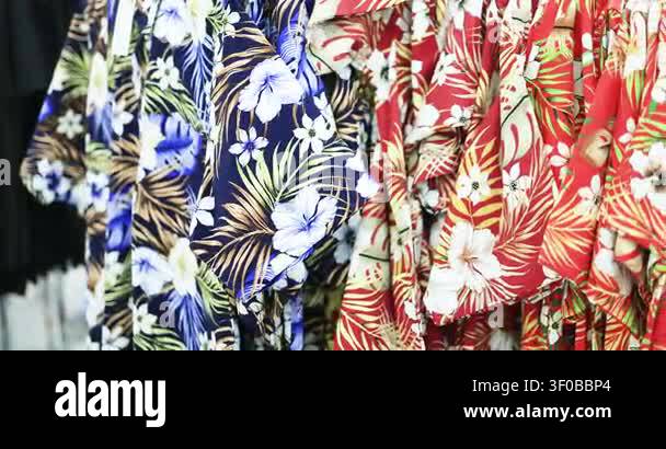 Colorful Hawaiian floral shirts hanging on a clothing rack in a retail ...