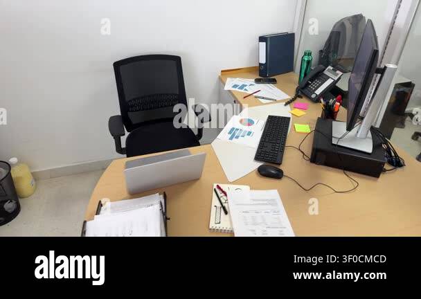 Unoccupied modern office desk with computer charts and laptop in a ...