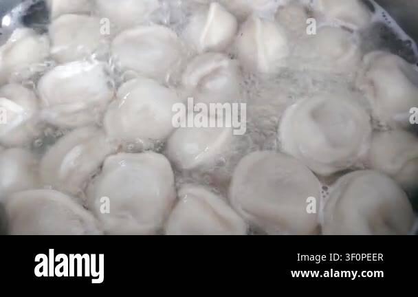 Boiling dumplings in a pot of water, showcasing the gradual cooking ...