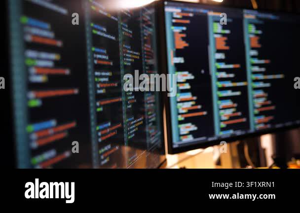 Close up computer monitors displaying fictional programming code and ...