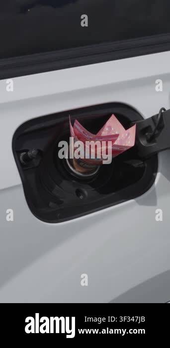 Close-up of female hand inserting euro cash into open fuel tank of ...