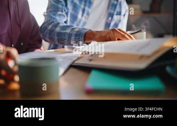 Hands multiethnic pair drawing design sketches, taking notes at wooden ...