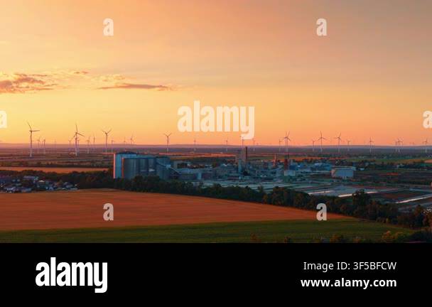 Aerial view of factory and wind farm across agricultural fields ...