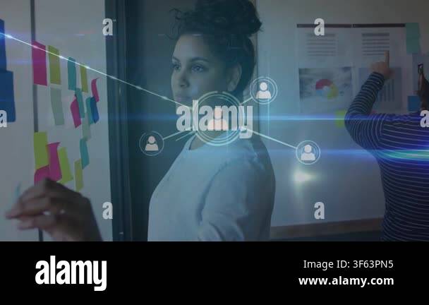 Woman stepping, adding notes on glass wall while network overlay ...