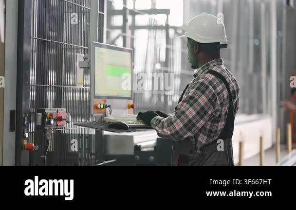 African american male factory worker operating a production line ...