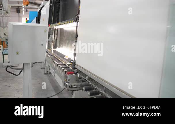 Industrial cnc press brake machine in action at a factory. An automated ...