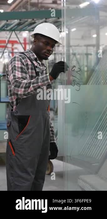 Professional african american man in a hard hat and overalls carefully ...