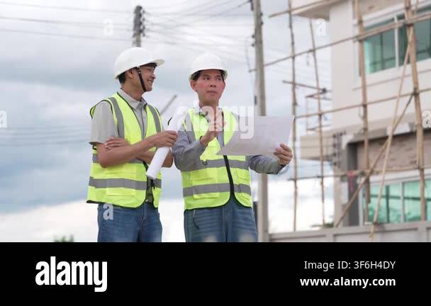Two Civil Engineers in Hard Hats and Safety Vests Inspecting ...