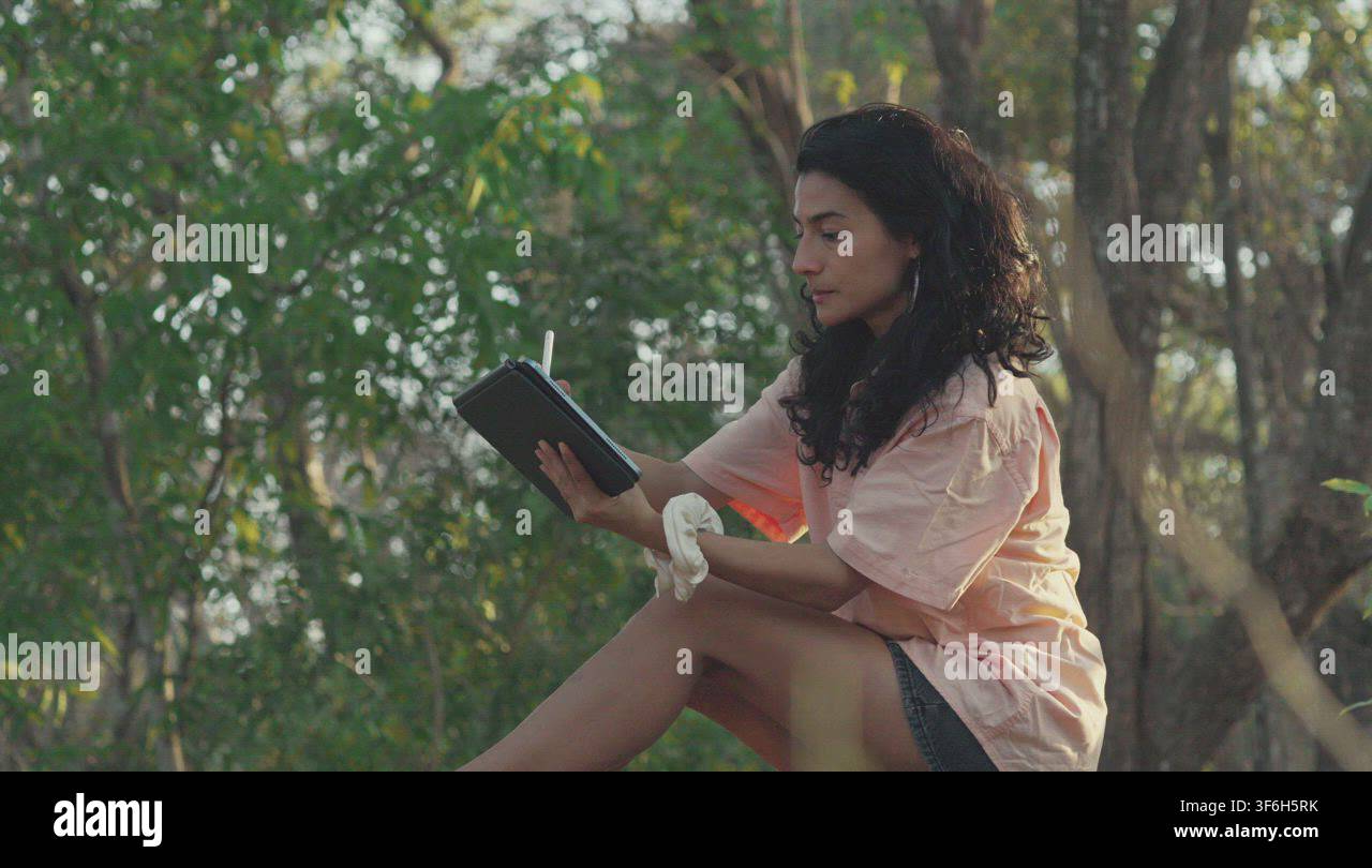 Digital artist drawing inspiration from nature on tablet Stock Video ...