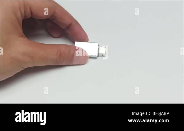Hand holding small silver metal usb type c adapter converter accessory ...