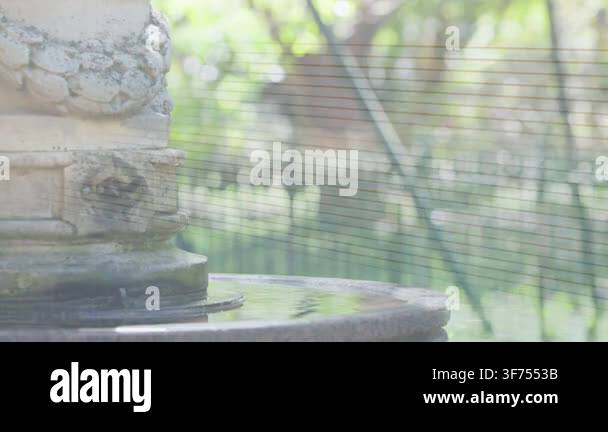 Droplet Stone fountain showing ripples after droplet falling, woman passing ...