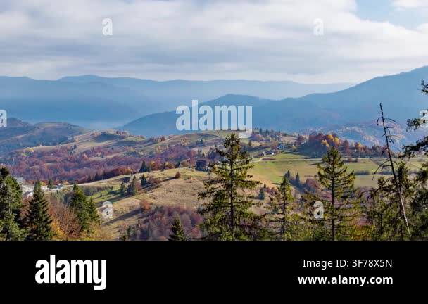 coniferous-treetops-against-highland-valley-with-scattered-houses-and