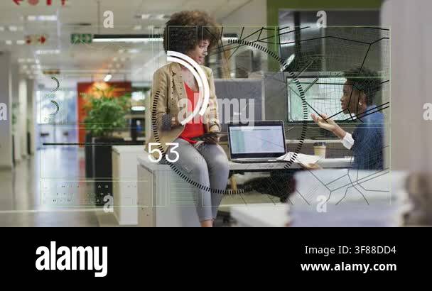 Woman tapping tablet initiating HUD over office peer pointing charts ...