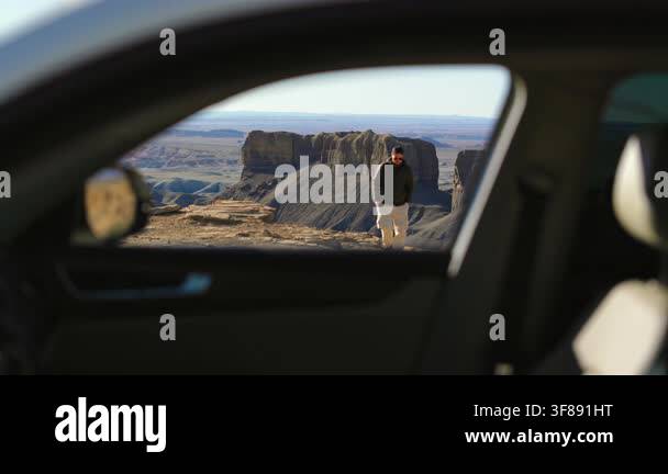 View through car window of man approaching vehicle at scenic desert ...