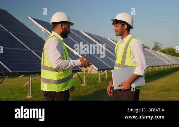 Two male multicultural engineers in hard hats and safety vests ...