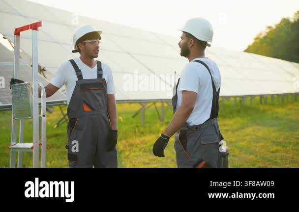Multicultural technicians discussing and shaking hands after successful ...
