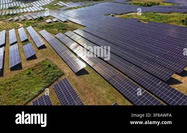 A renewable energy farm shows many solar panels arranged in rows ...