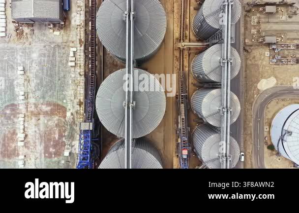 This shows large silos arranged in rows at an industrial site. Heavy ...