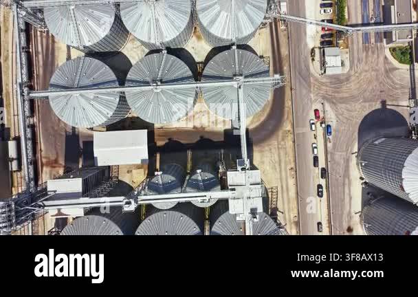 An aerial view captures a grain storage facility. The scene shows large ...