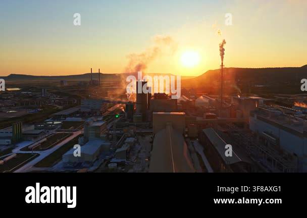A view of industrial buildings as the sun rises in the background ...