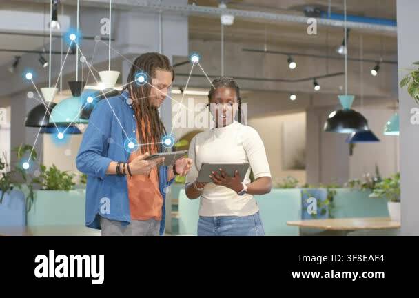 Man pointing tablet, woman tapping screen in tech hub, network overlay ...