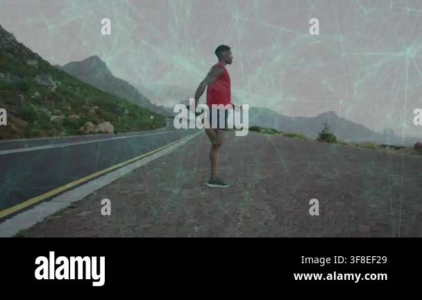 Male runner doing quad stretch on lot preparing for fitness run with ...