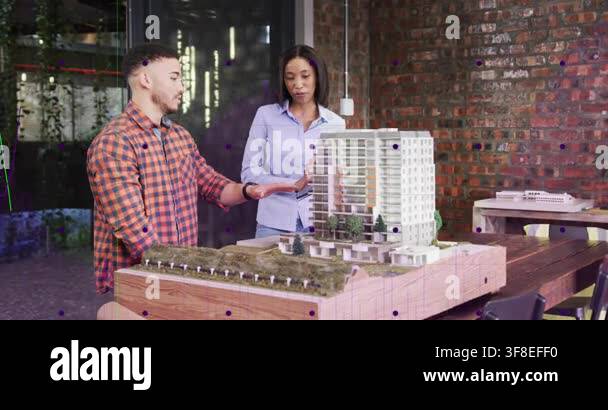Man gesturing, woman pointing and tracing scale model while showing ...