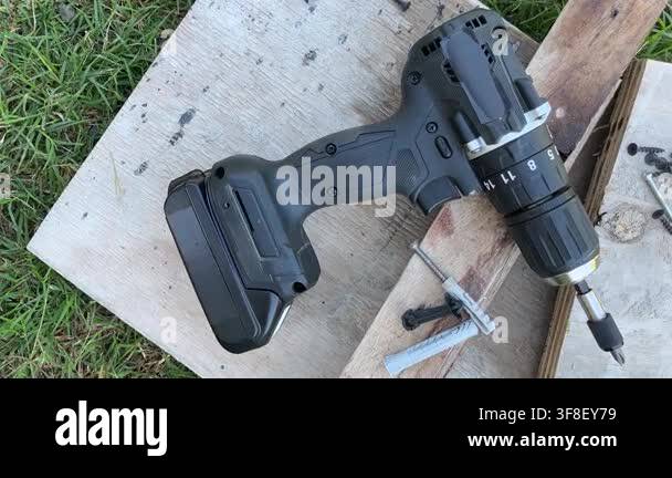 Top view of a professional cordless screwdriver next to tools and items ...