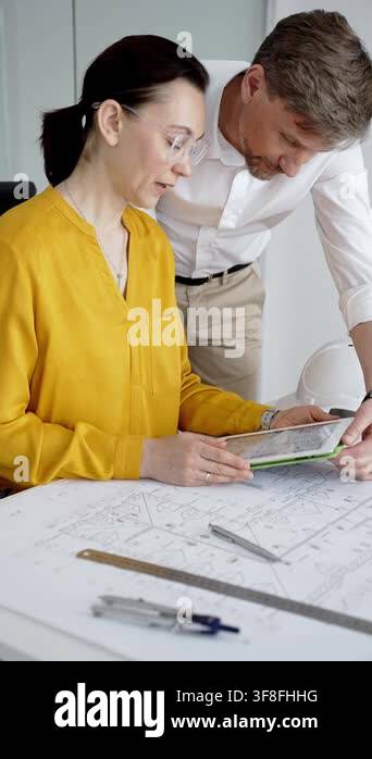 Adult professionals discussing project details and architectural ...