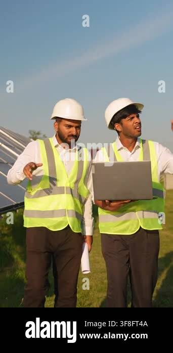 Two indian engineers wearing hard hats and safety vests walking through ...