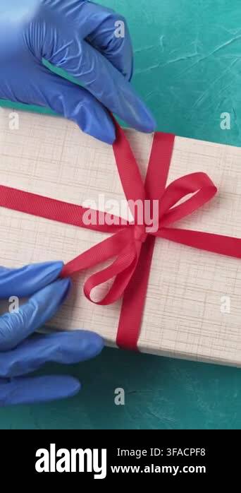 Red Box Vertical video. Pandemic present. Gift box. Hands in protective gloves ...