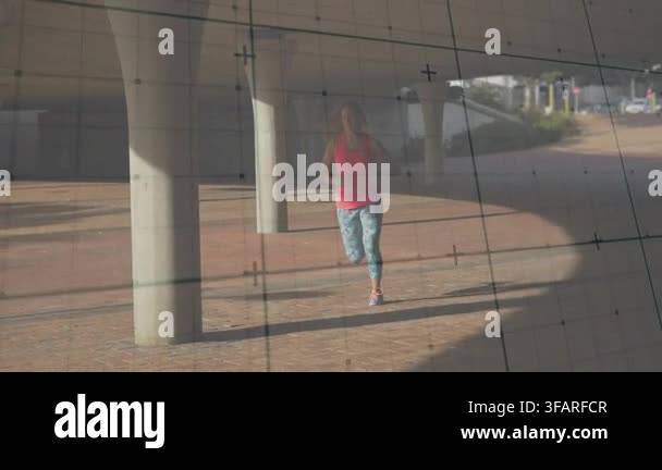 Female runner starting jog, approaching camera, passing canopy columns ...