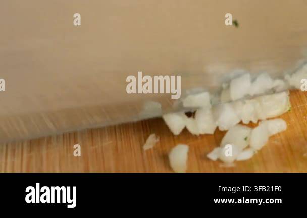 chef-chops-fresh-garlic-cloves-on-a-wooden-cutting-board-with-a-metal