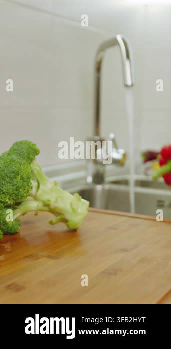in-a-bright-kitchen-a-person-washes-fresh-bell-peppers-and-places-them