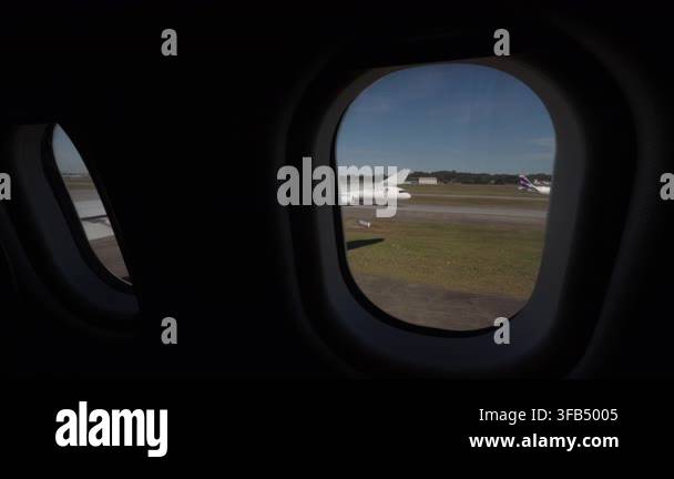 View From An Airplane Cabin Through Oval Windows As The Plane Rolls view-from-an-airplane-cabin-through-oval-windows-as-the-plane-rolls