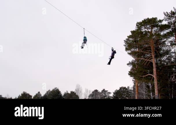 zip-line-ropes-in-winter-park-instructor-helps-child-zip-lining-on