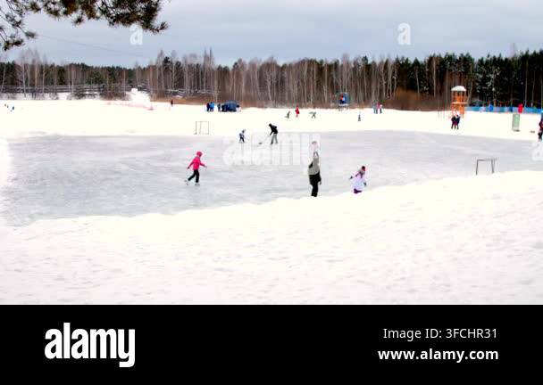 children-skate-on-ice-rink-in-winter-kids-and-parents-play-hockey-and
