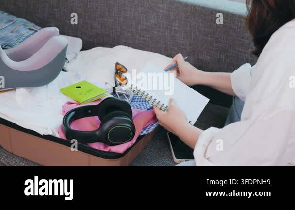 Woman Writing A Packing List For Summer Vacation An Open Suitcase With woman-writing-a-packing-list-for-summer-vacation-an-open-suitcase-with