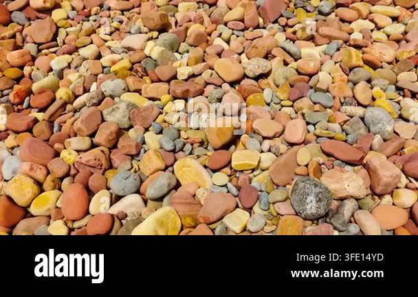 Colorful beach pebbles and smooth rounded stones in red, yellow, orange ...