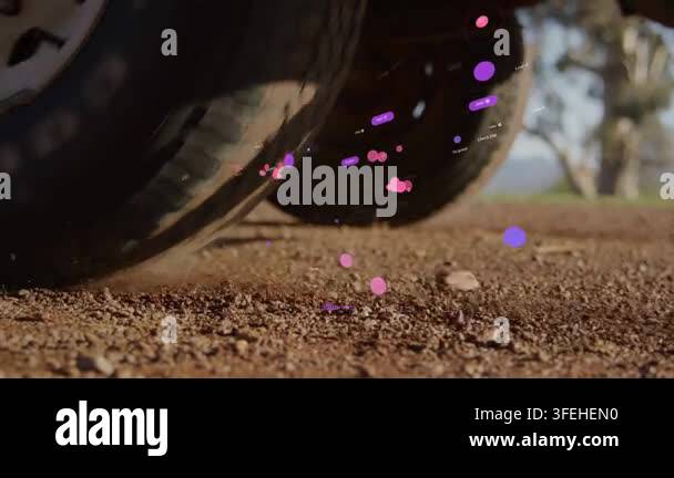 Vehicle rear wheels rolling on gravel, kicking dust and displaying ...