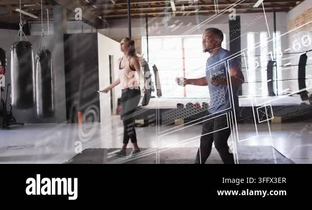 Workout partners in loft studio rotating ropes, matching hops while HUD ...
