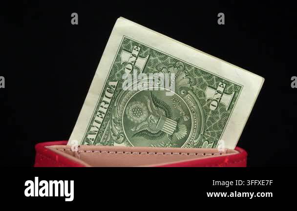 One US dollar banknote in a red wallet, symbolizing American currency ...