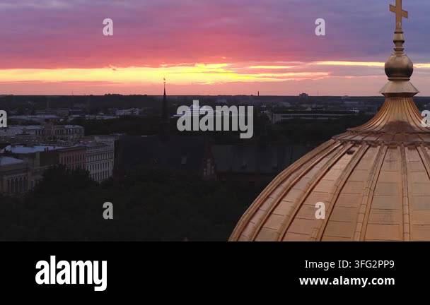 An aerial view reveals the Riga cityscape during a colorful sunset