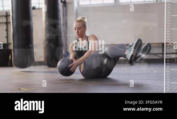 A Frame Rotation Exercise Woman doing seated twists in fitness gym, starting rep holding medicine ...